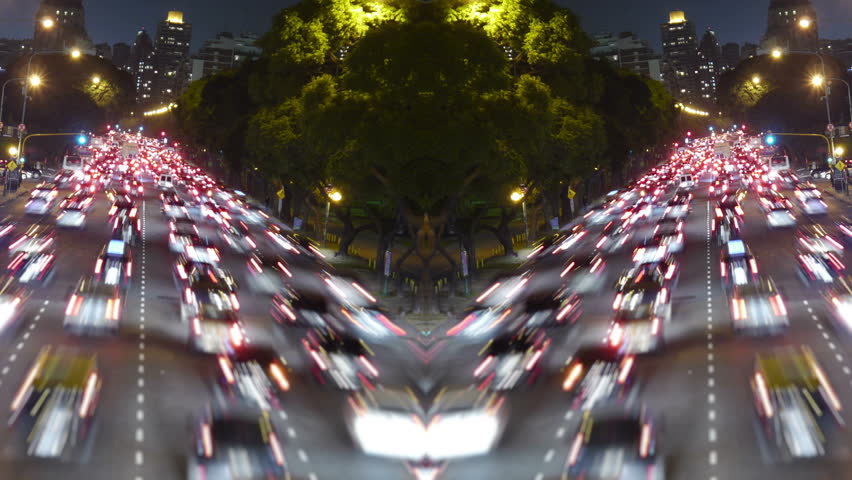 Traffic in the city. Avenue Time-Lapse, symmetric / mirrored, Night. Moon going down. Heavy traffic / jam / flowing with blurred motion.