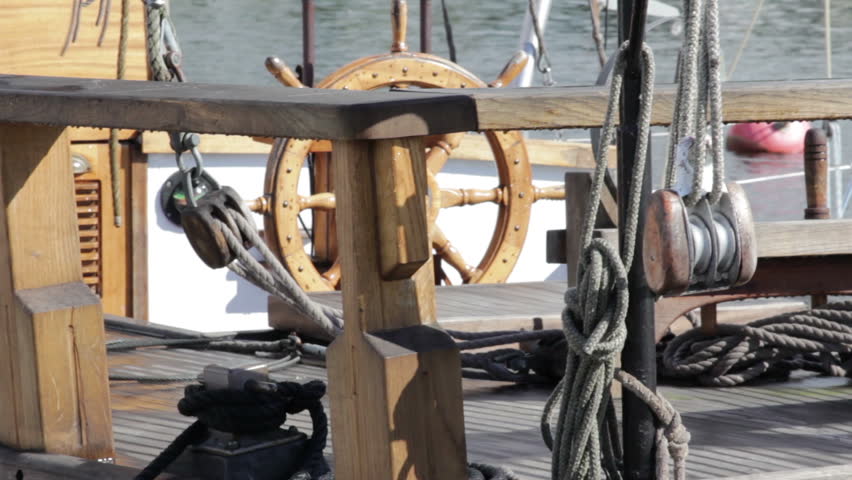 Ropes, tackle and old steering wheel from wood on an old sailing ship. 