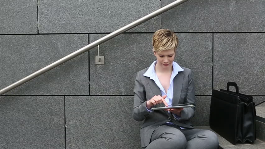 Business woman working with tablet PC outside and holding thumbs up
