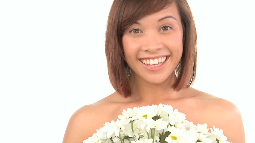 Young western oriental girl enjoying the therapeutic aroma of flowers