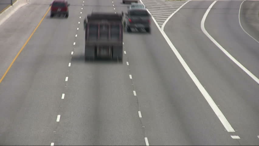 Video time lapse of vehicle, car and truck traffic driving away from view from overpass. High speed multiple lane freeway highway. San Antonio Texas. Don Despain of Rekindle Photo