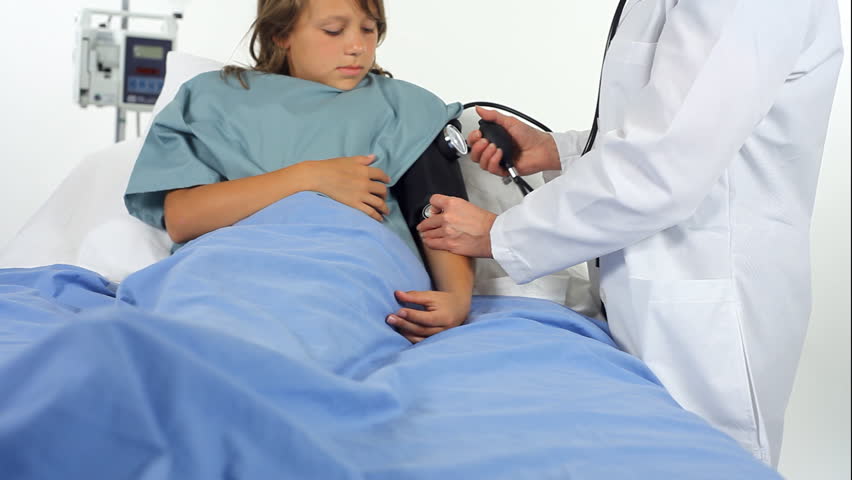 A doctor or nurse in a hospital, checking a young patientÃÆÃÂ¢Ãâ?Ãâ?s blood pressure.