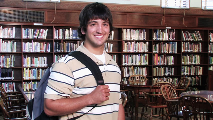 A confident student proudly looks at the camera and smiles.