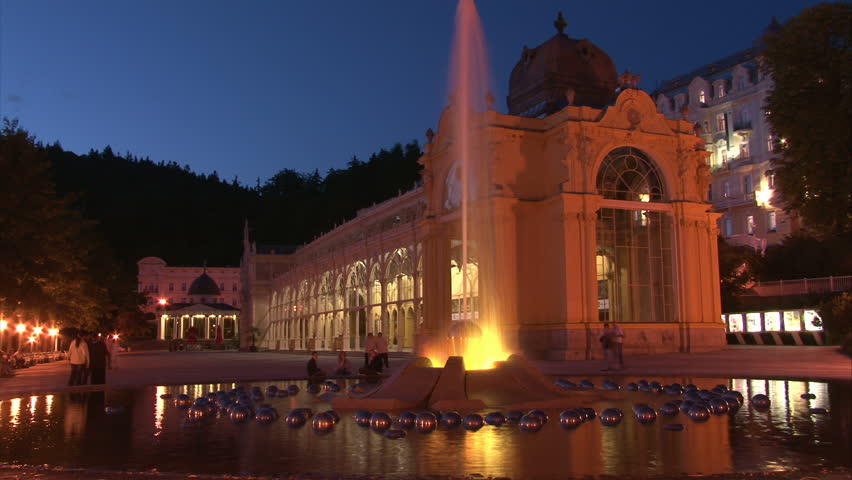 Illuminated Pseudo-Baroque cast iron unique City Colonnade in Marianske Lazne (West Bohemia, Czech) with walking people and fountain. Time lapse.