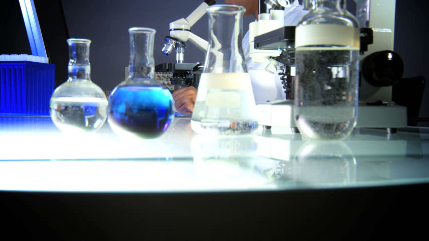 Medical professional working in lab with microscope and computer