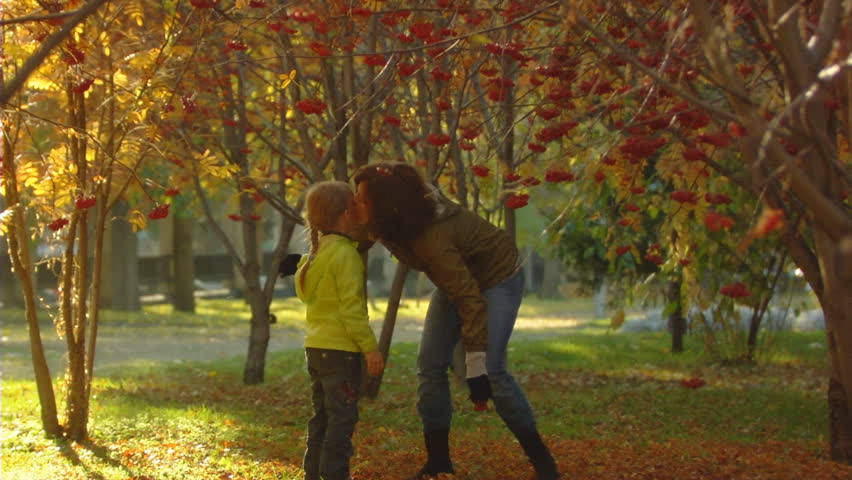 Slow motion shot of the happy mum and little girl in autumn park