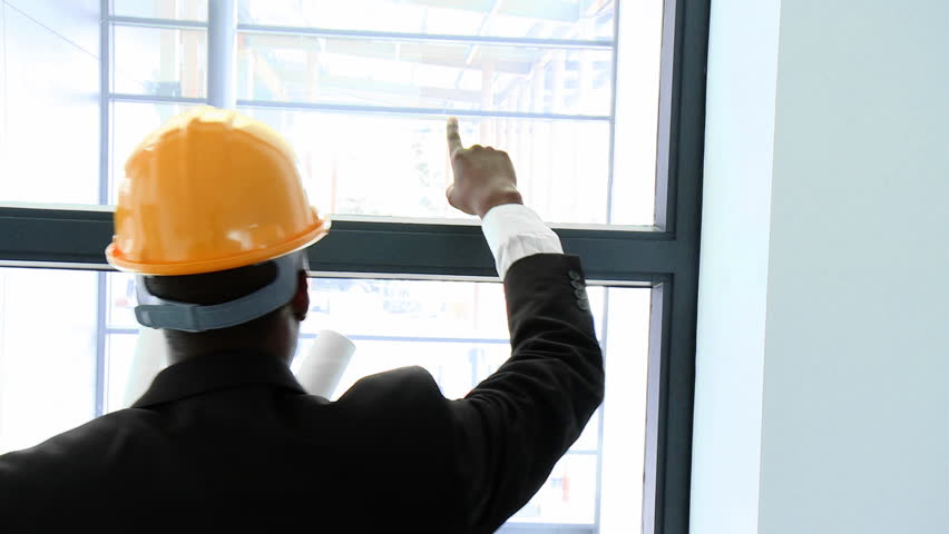 Afro-American architect studying a building through a window