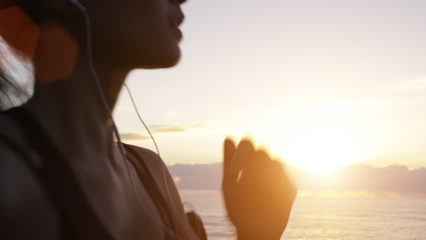 Mixed race woman runner running on beach road