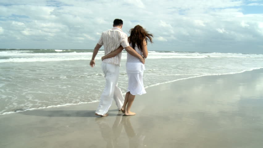 Attractive young caucasian sweethearts walking together on the beach 60 FPS