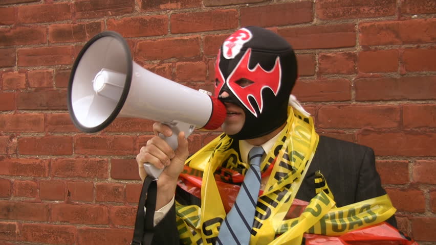 Scary boss. A businessman with megaphone, Mexican wrestling mask and "CAUTION" and "DANGER" tape. Slight timelapse effect applied. 