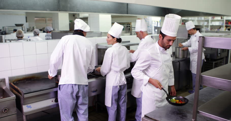 Busy Kitchen chefs at work in a busy kitchen in a commercial kitchen stock Busy Kitchen chefs at work in a busy kitchen in a commercial kitchen stock