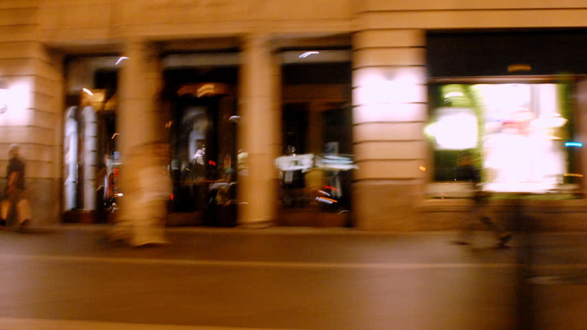 Zooming by city streets and sidewalks at night time lapse