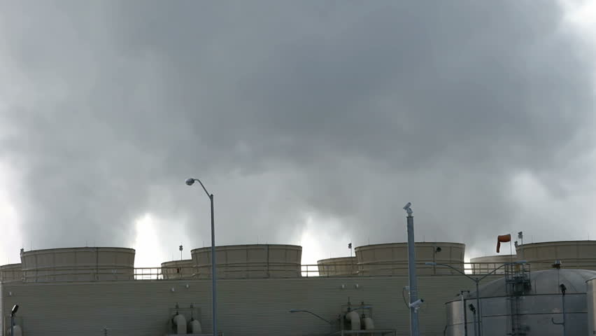 Pollution and steam spewing from cooling towers and smoke stacks of a natural gas electrical generating power plant. Fast motion time lapse. 