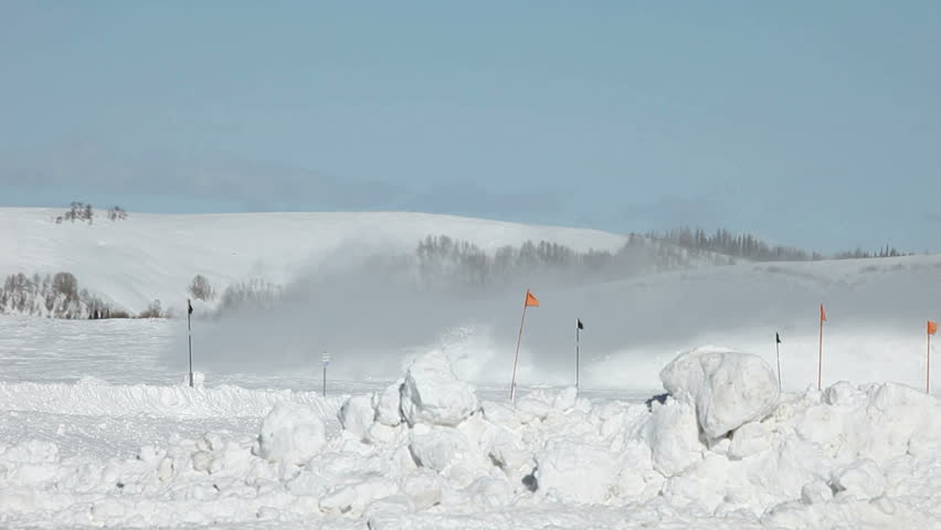Snow being blown long distance by high powered mountain snowblower. High in Rocky Mountains after a winter snow storm. Snow thrown a log way from road.