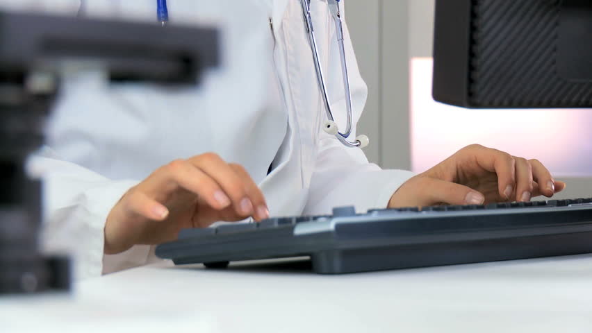 Female research scientist using modern computer technology for medical data in laboratory