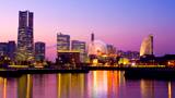 Yokohama's Landmark Tower at night, water bus activity on river, time-lapse