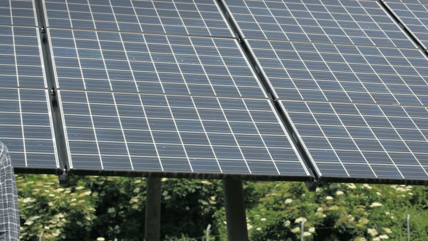 Electrician working in solar power station and smiling at camera