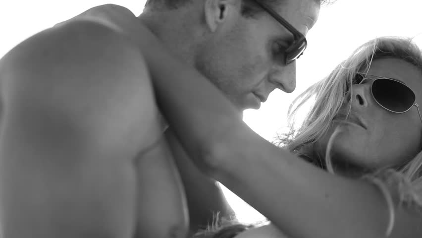 Sensual attractive young couple holding each other outdoors filmed in monochrome