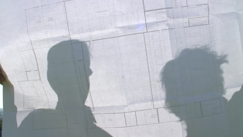 HD 1080i: Shadows of two people on a construction plan discussing. Tripod.