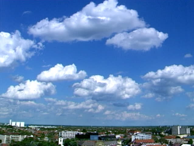 Clouds passing over a blue sky, above the city.