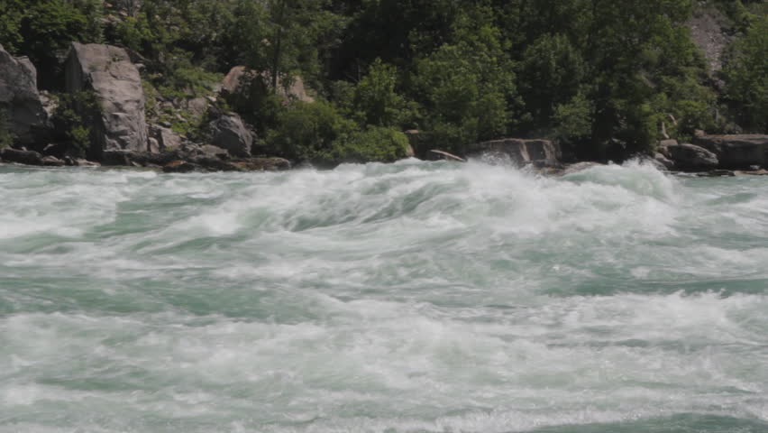 Niagara river rapids. Medium shot. Intense Class 6 white-water rapids speed by in the Niagara river. One of the world's wildest stretches of whitewater, located about 4km below Niagara Falls.  