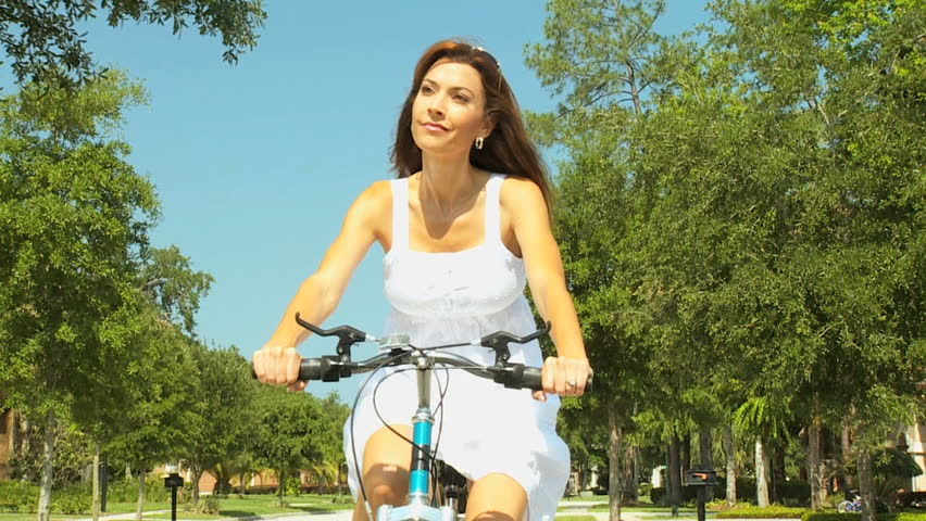 Healthy attractive brunette lady enjoying the fresh air & exercise while out cycling 60FPS