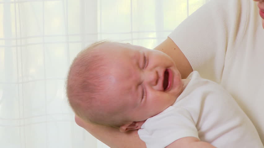 Stressful mother working on lap top with baby