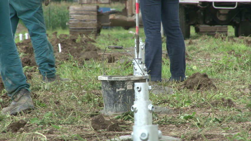Workers are tuning the right pillar position in cement for solar power plant construction. 