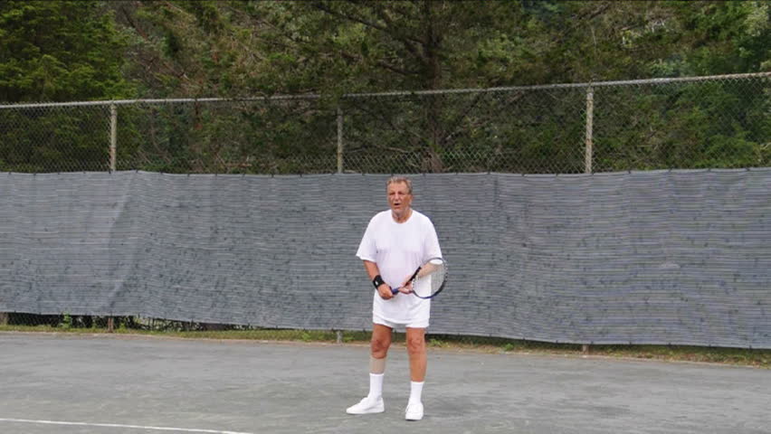 handsome senior male tennis player practicing tennis top spin lob stroke 
