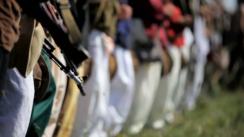 Muslim warriors. Several soldiers in Muslim clothing and armed with Kalashnikov rifles stand in a row.