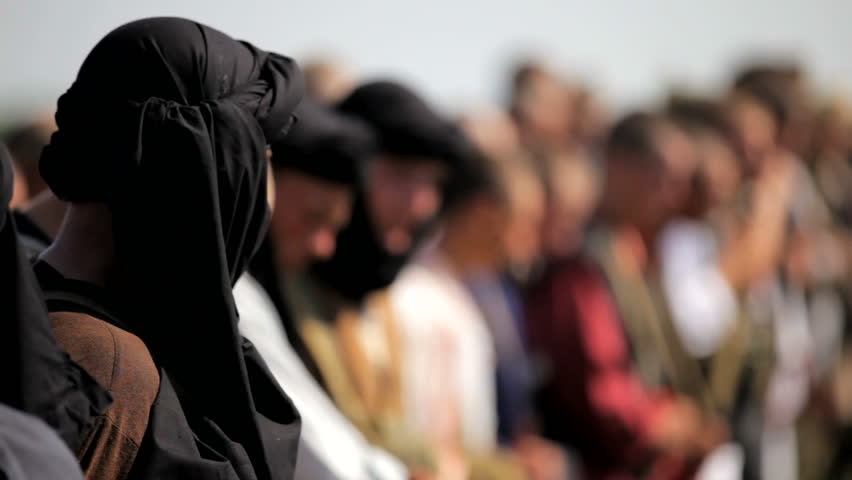 Muslims stand in a row. Dressed in Muslim clothes soldiers.