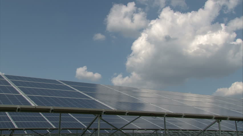 Solar power plant panels with flowing clouds and shadow changes. Time lapse.