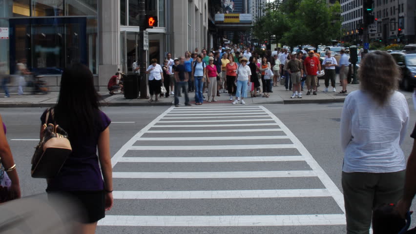 Crowds crossing urban street time lapse
