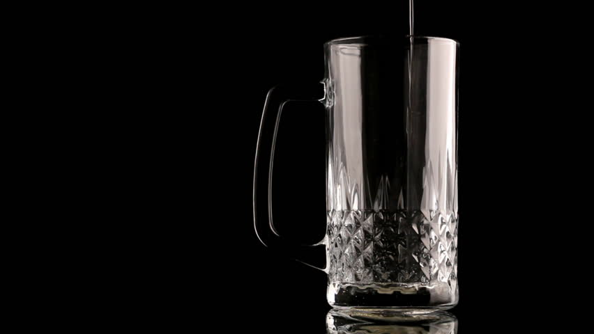 Beer poured in glass on black background