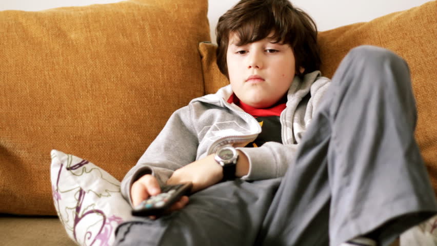 Young bored boy watching tv