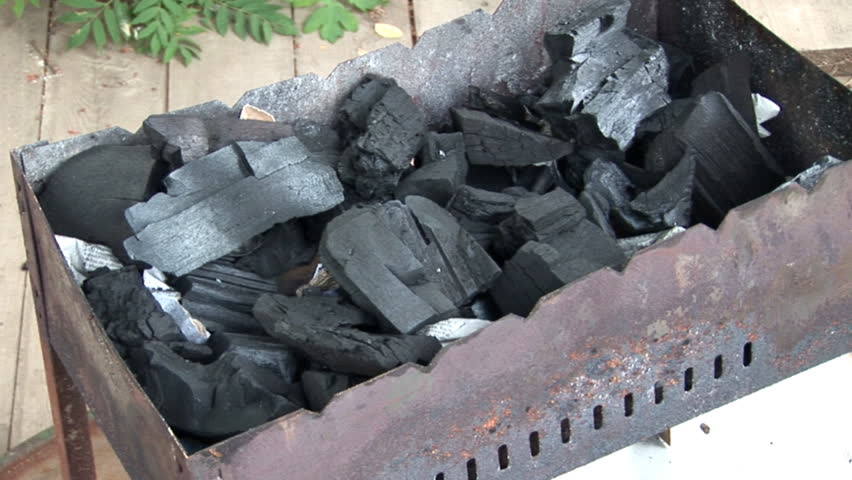 pouring the liquid fuel on BBQ charcoals