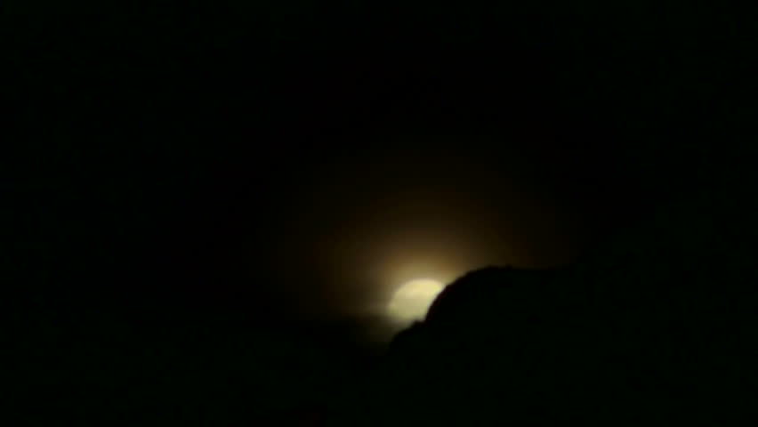 Time Lapse - Moonrise over mountaintop obscured by swirling clouds. 1920x1080