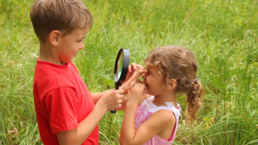  sister is looking at her brother through the lens and laughing merrily.  