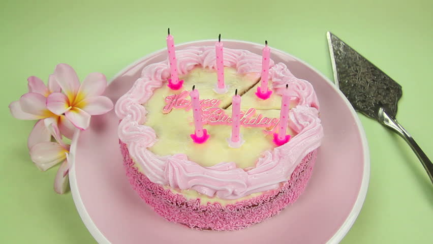 Edited sequence of birthday cake candles being blown out then the cake sliced.