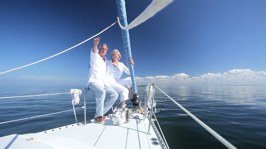 Healthy retired couple enjoying leisure aboard their luxury sailing boat