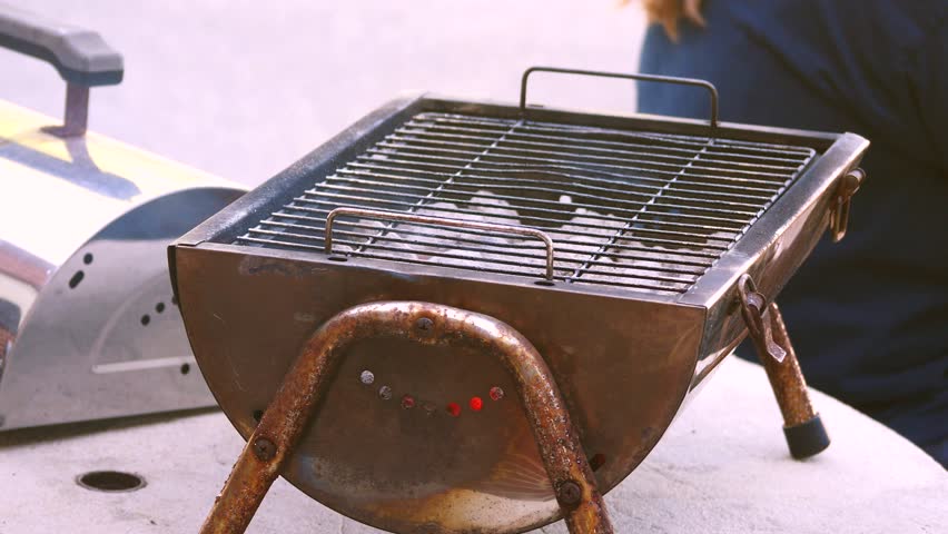 Portable Tabletop Charcoal Grill With Stock Footage Video 100 Portable Tabletop Charcoal Grill With Instances Of Fire Visible Through Tiny Holes A Person S Back In Background