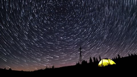 Time Lapse Of Star Trails In The Night Sky Over Mountains And Glowing Tent 4k