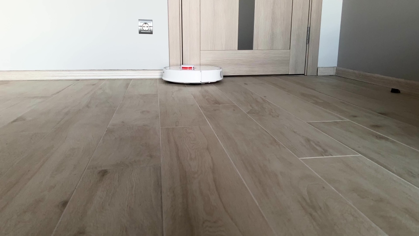 Smart House Vacuum Cleaner Robot Runs On Wood Floor In A Living