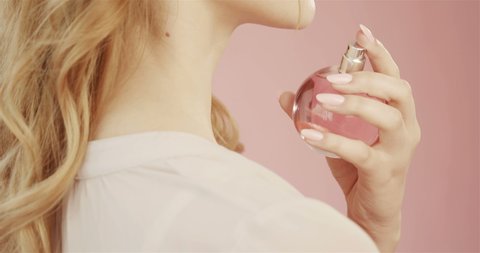 480px x 253px - Beautiful cute tender young girl with nude makeup holds bottle of perfume  with pink liquid, in studio on pink background. concept for advertising  perfume. gentle makeup and developing hair.