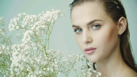 480px x 270px - Portrait of girl with clean smooth skin, nude makeup against the background  of branches of gypsophila plant in studio. natural and organic cosmetics,  skin care, shampoo. girl posing for camera.