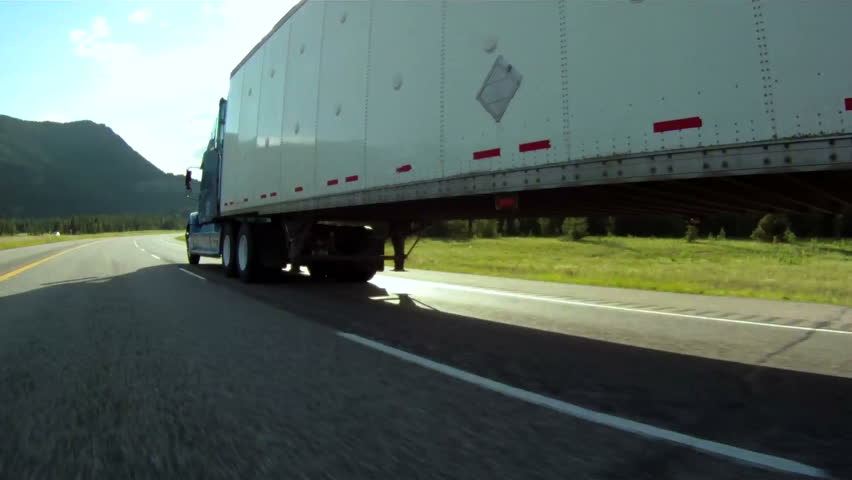Vehicle pov shot of semi trailer truck traffic on highway