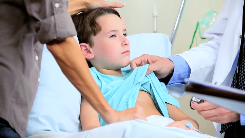 Male Doctor With Nurse Diagnosing A Young Boy Patient In -3330