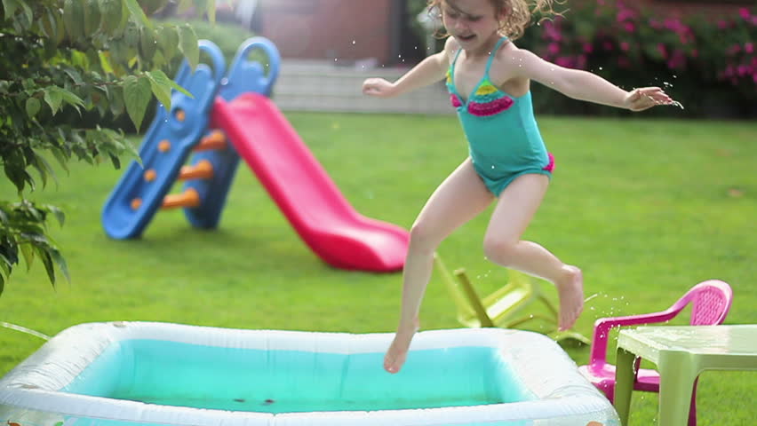 Energetic Little Girl Swims And Jumps Around In Backyard Swimming Pool ...