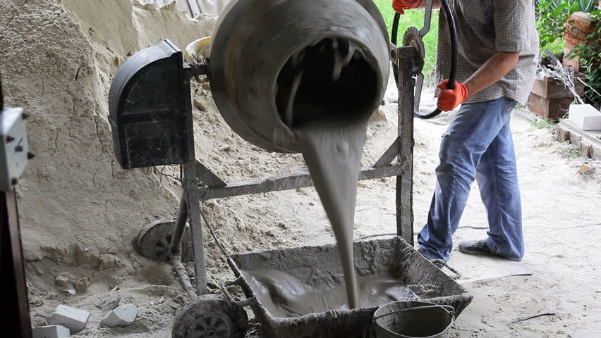 Worker With A Concrete Mixer Worker Is Pouring Concrete From Cement