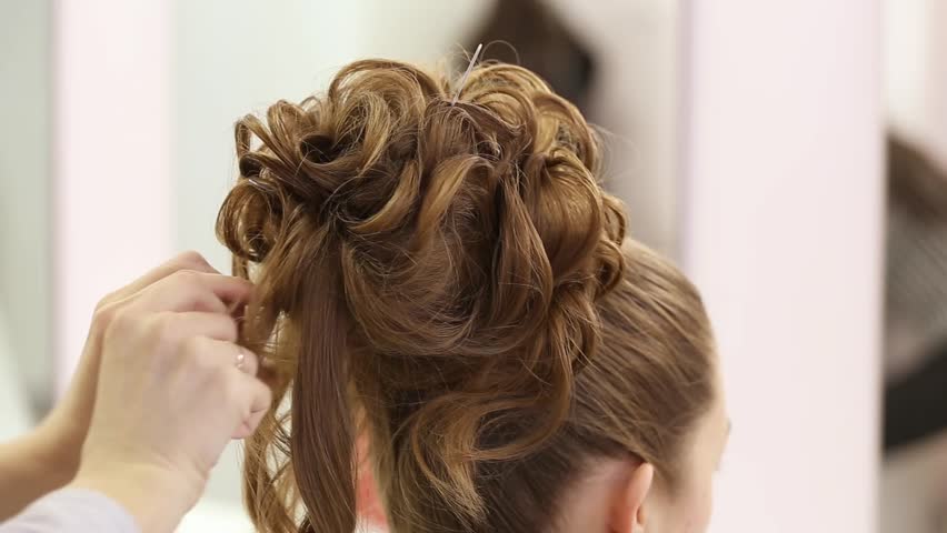Professional Hairdresser Doing Hairstyle With Bun And Curls For